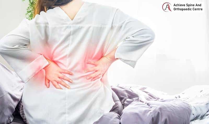 Woman holding her spine due to pain