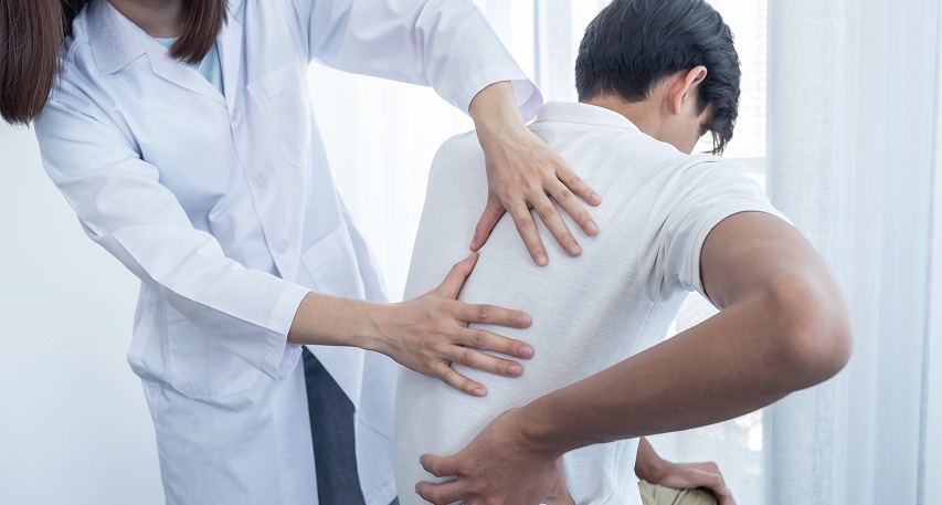 female doctor hands doing physical therapy by extending back male patient
