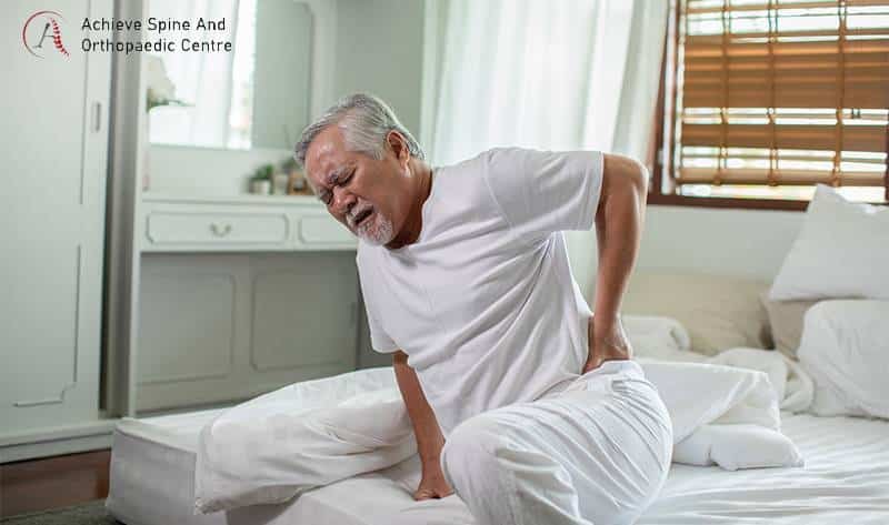 Elderly man waking up with herniated disc pain.