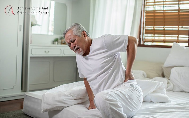 Elderly man waking up with herniated disc pain.