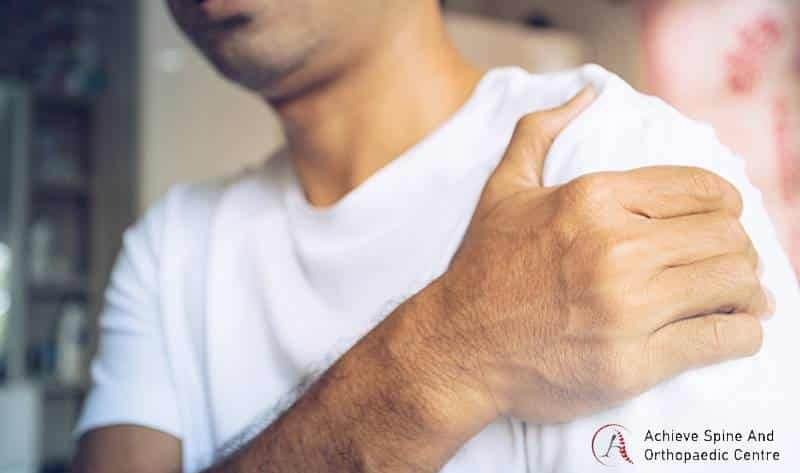 Man clutching arm due to radiating pain.
