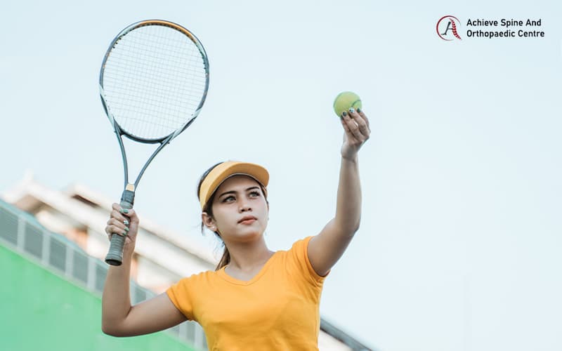 Young female tennis athlete preparing to serve a ball.