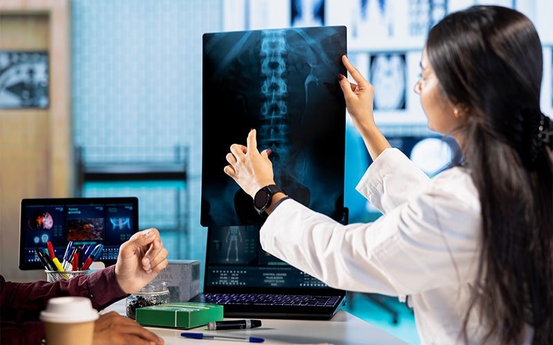 Doctor analyzing a spinal X-ray film.